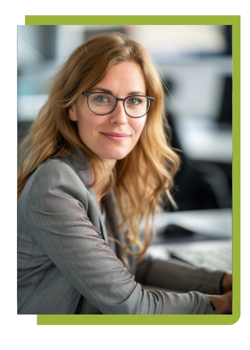 KI Anwenden Erwachsene Frau ( dunklelblonde Haare, leichtes Lächel, possitive Ausstrahlung) im beruflichen Weiterbildungsumfeld, sitzt im Schulungsraum und arbeitet am Desktop, modernes Arbeitsumfeld, KI-gestützte Arbeitsweise ohne sichtbare Tools, Fokus auf Arbeitskompetenz und Effizienz,